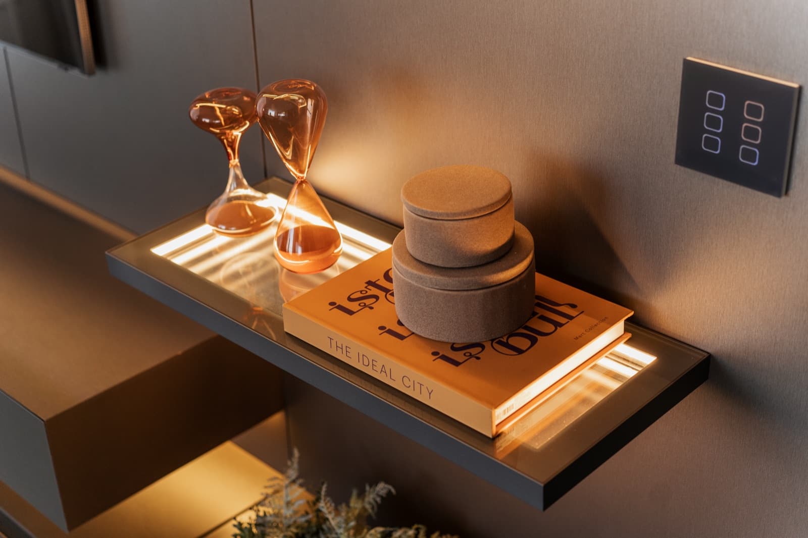Prateleira flutuante em vidro iluminada com objetos decorativos