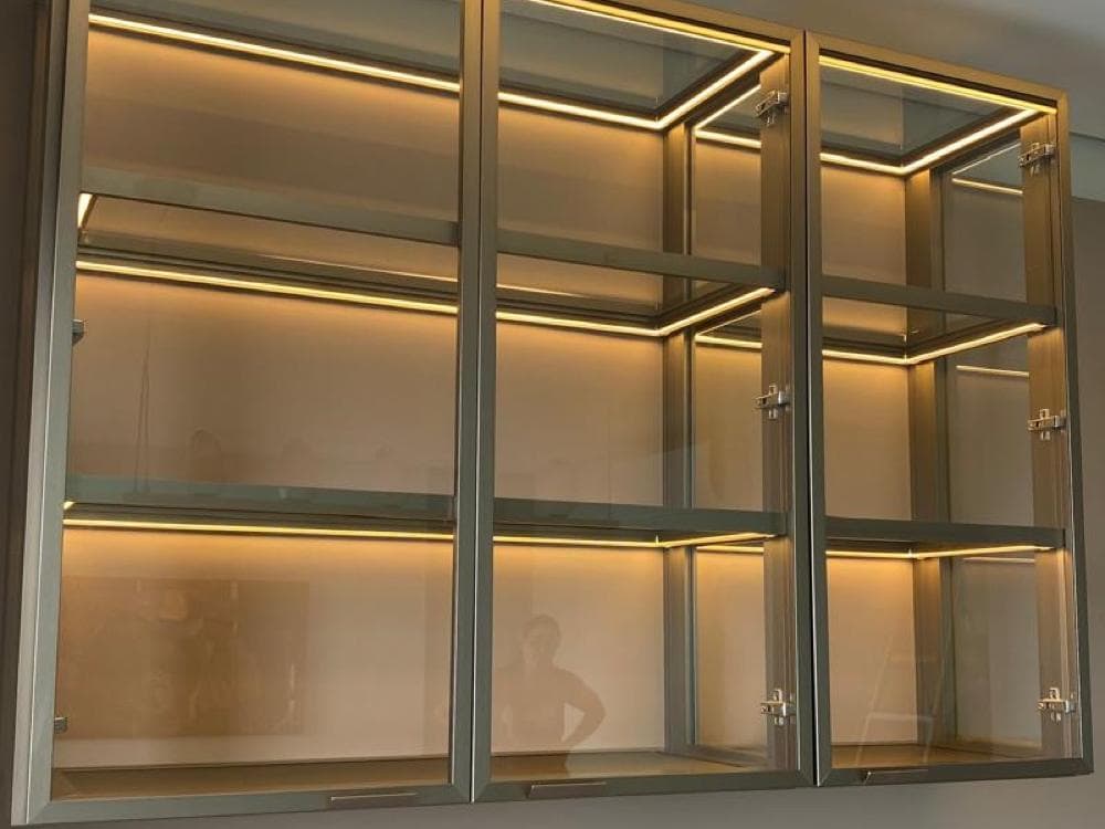Cristaleira em vidro e alumínio com iluminação embutida em cada nicho