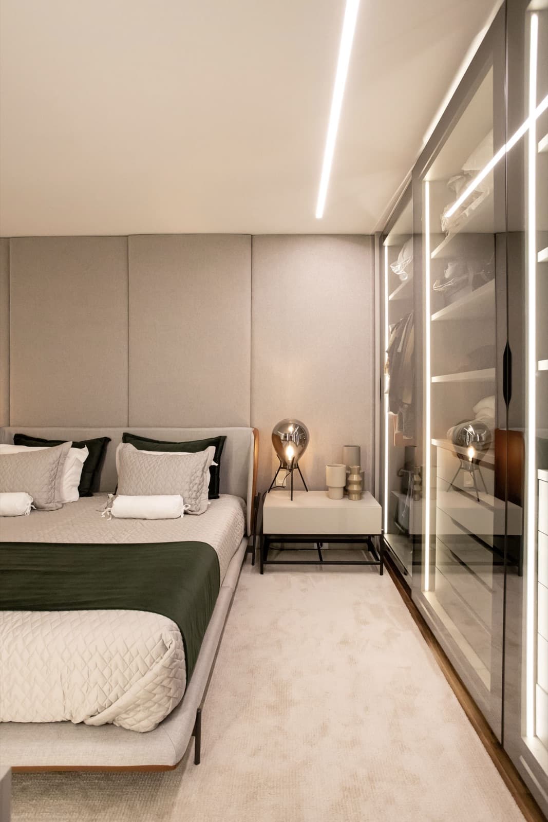 Closet espelhado com portas de vidro e alumínio ao lado da cama